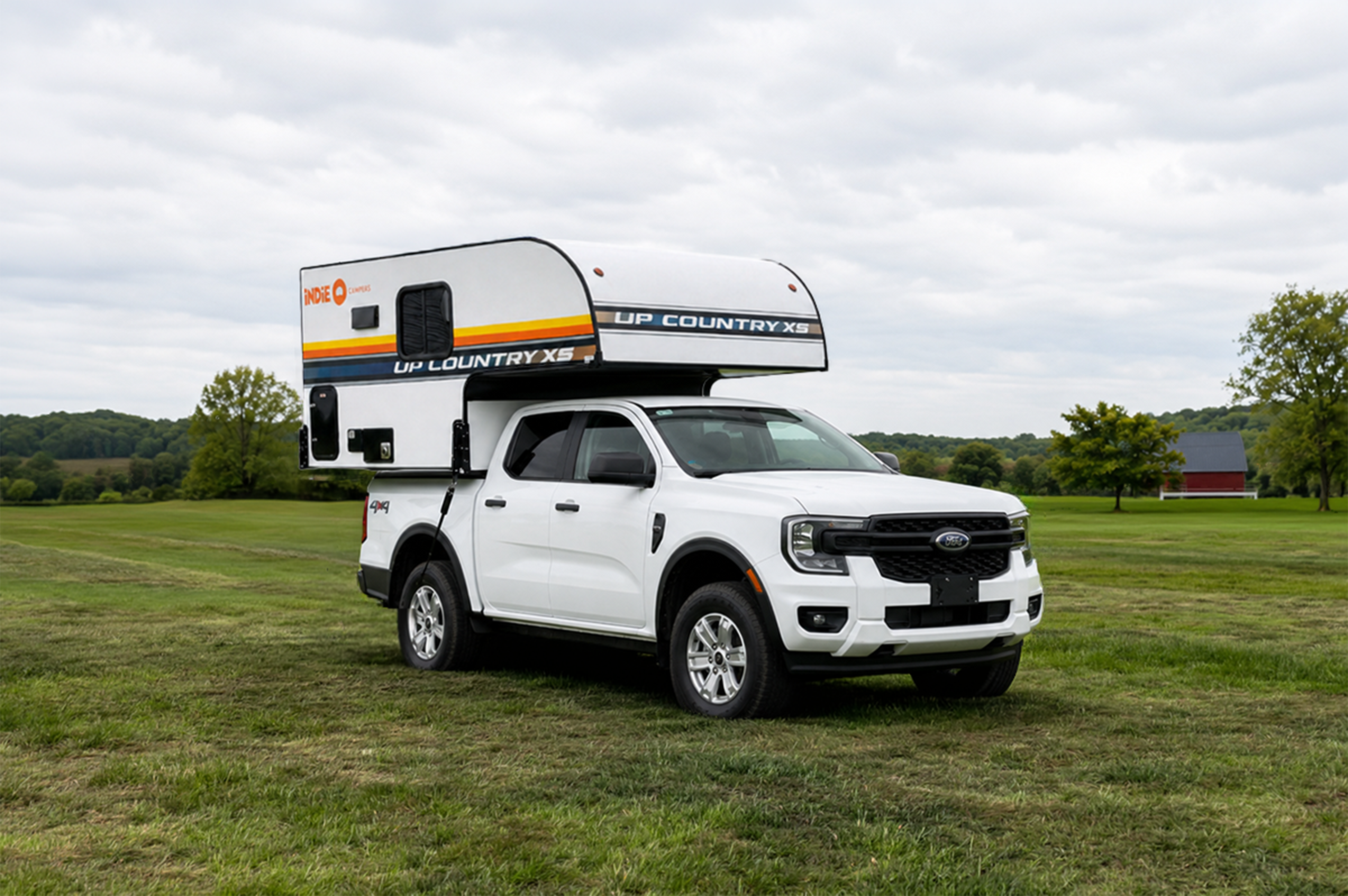 Front side view of medium-sized pickup camper with over-cab sleeping area and compact, box-shaped rear layout.