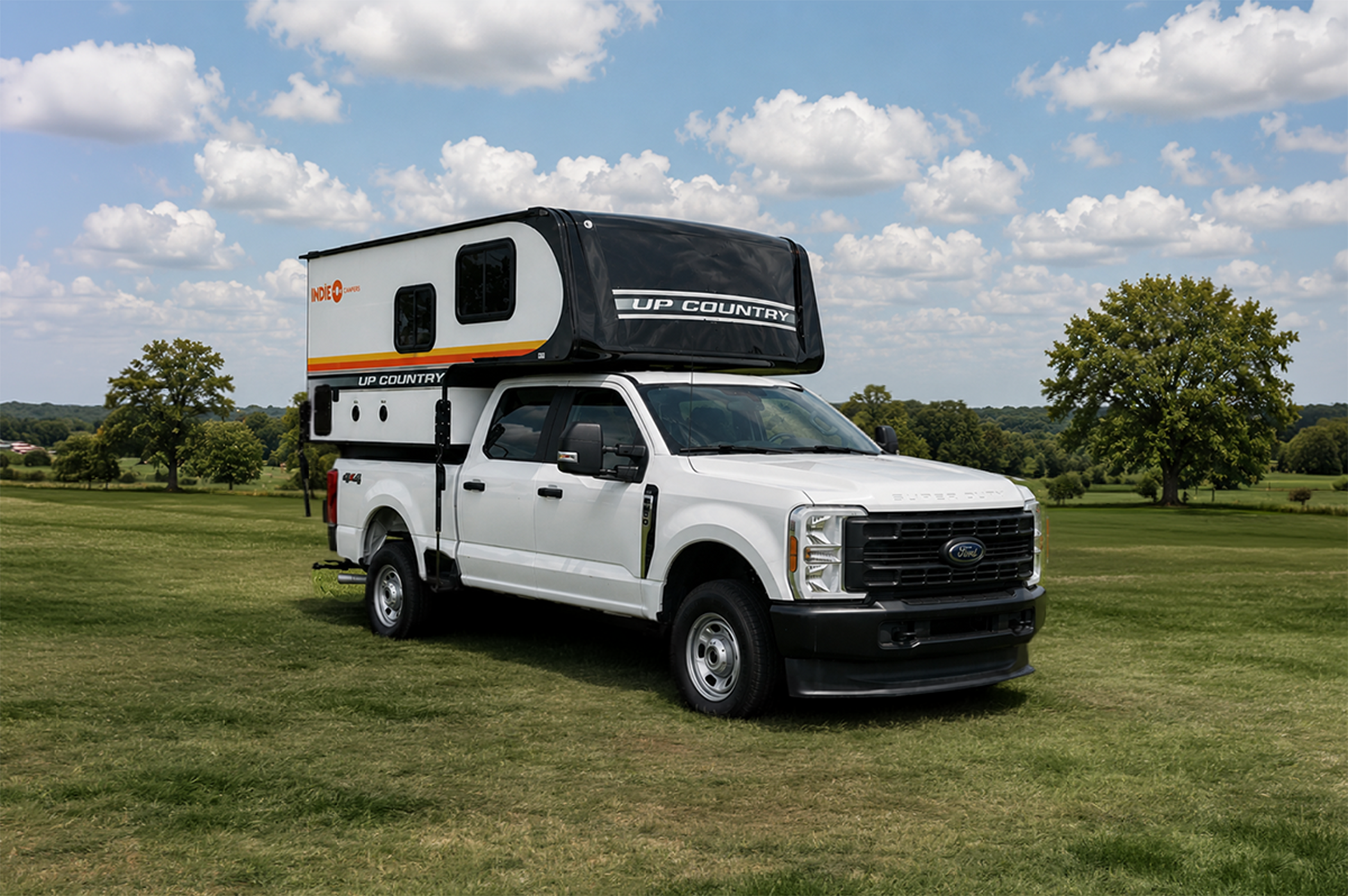 Front-side view of medium truck camper with an over-cab sleeping area, no roof tent visible.