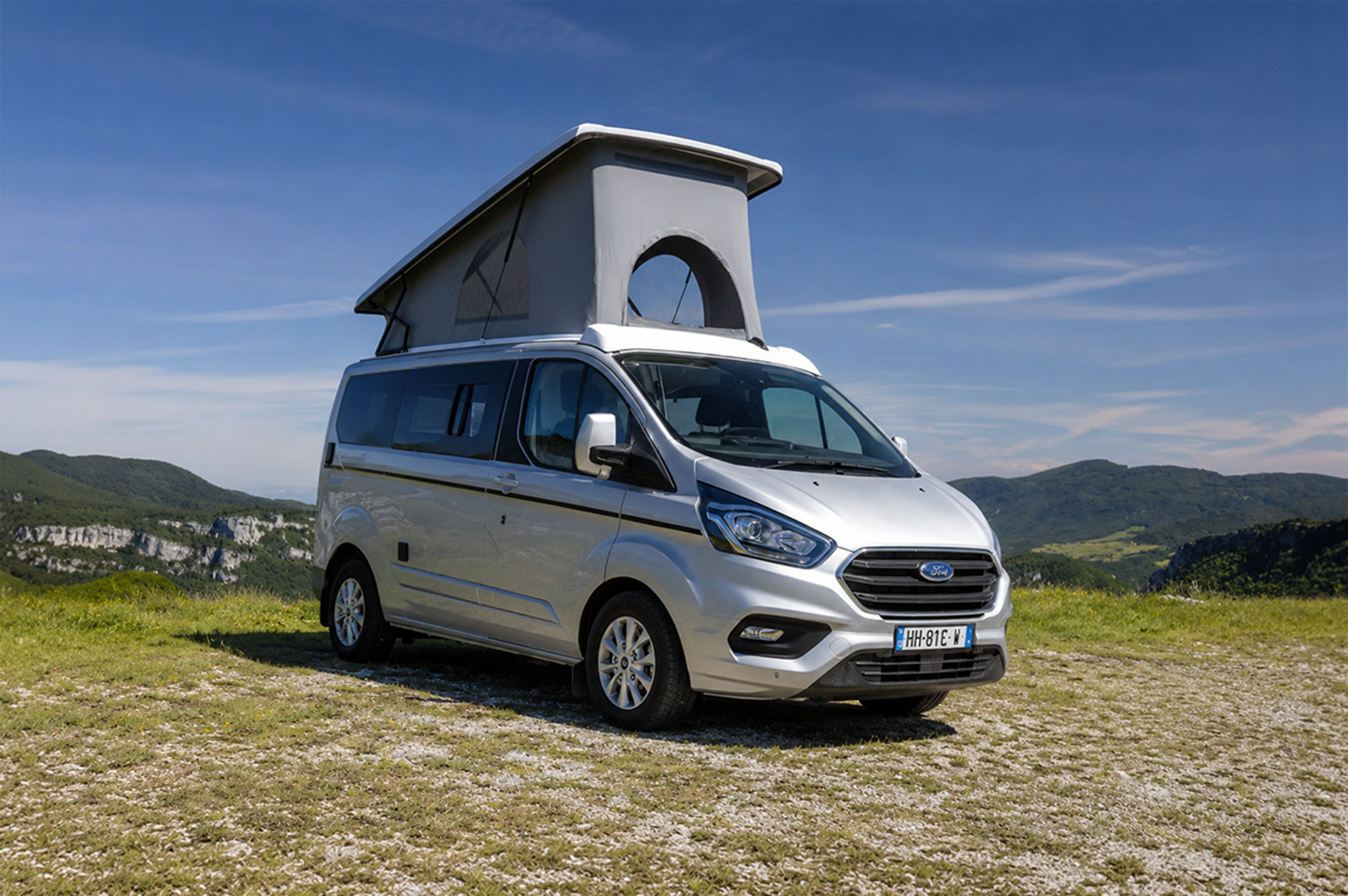 Front side view of medium campervan with raised roof tent.