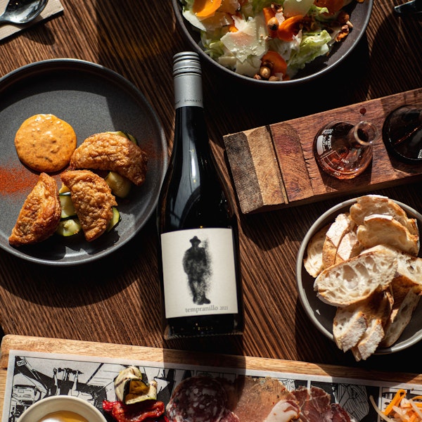 Bottle of Tempranillo on a table surrounded by food