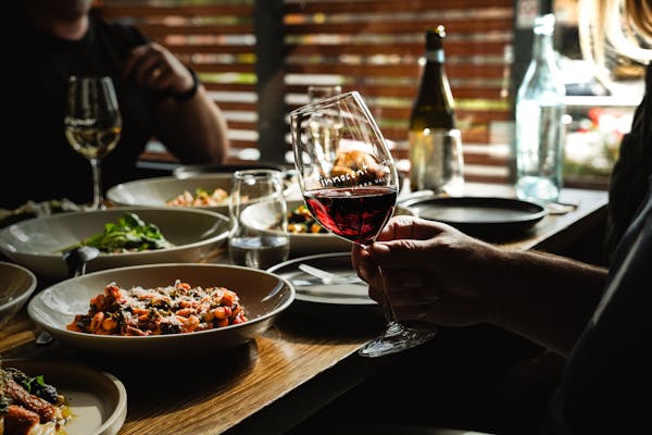 swirling wine with food in background