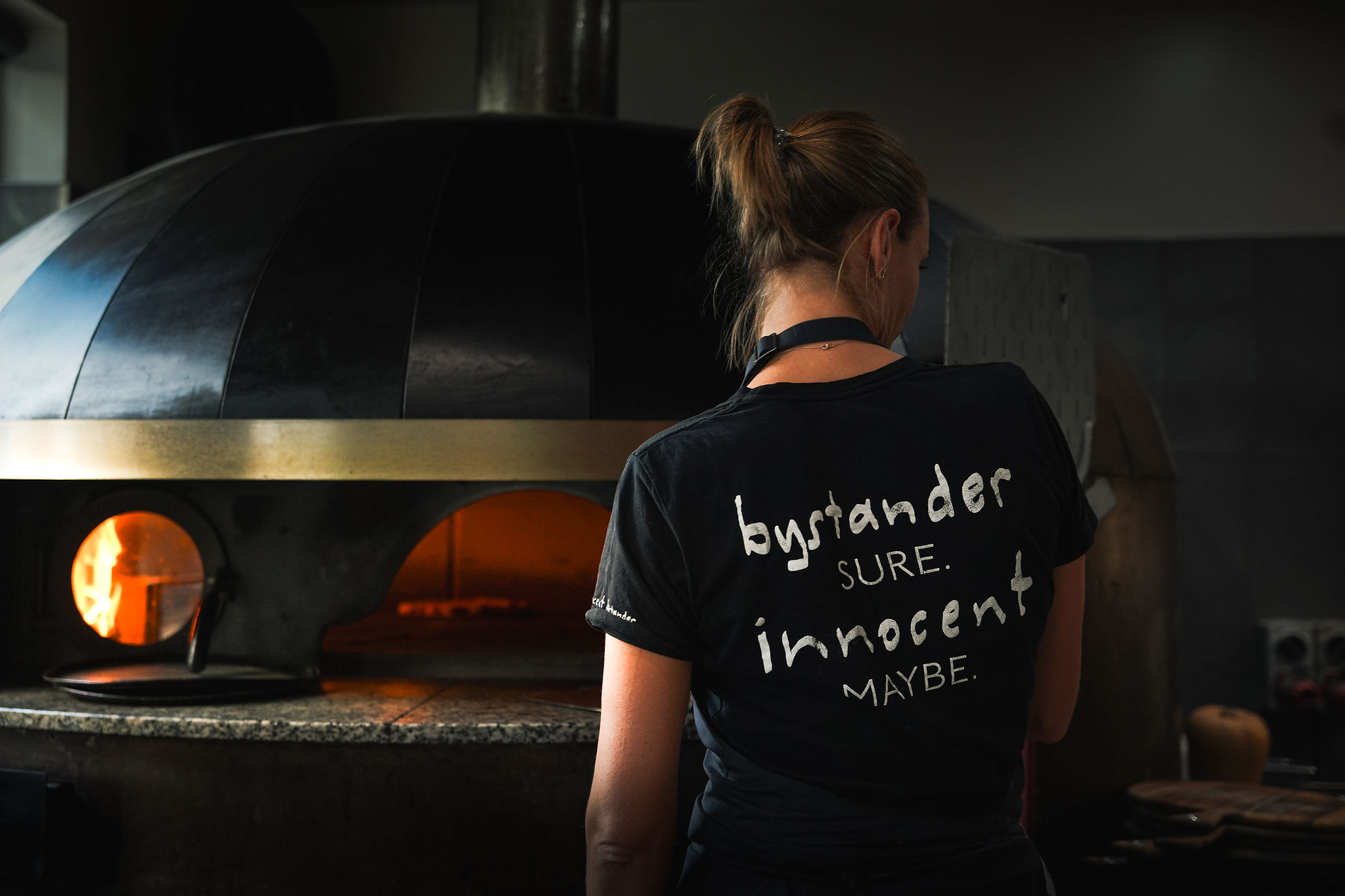 G in front of the pizza oven