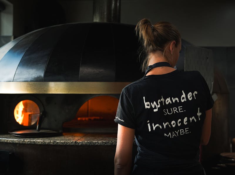 G in front of the pizza oven