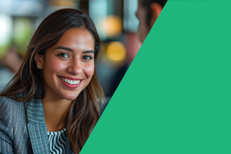 A smiling woman in a professional environment, representing confidence and workplace culture.