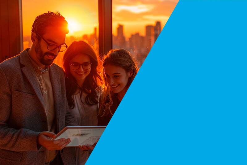 Professionals reviewing a document together in an office at sunset, highlighting teamwork and shared focus.