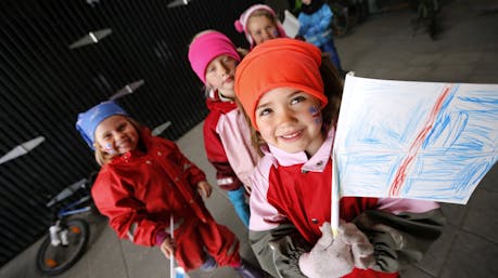 Young Icelandic children holding hand-drawn Icelandic flag. 
