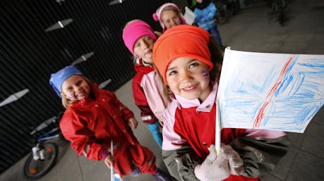 Young Icelandic children holding hand-drawn Icelandic flag.