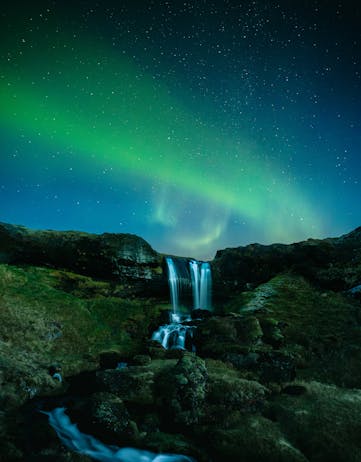 Northern lights over a waterfall