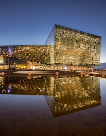 A picture of Harpa Concert Hall in Reykjavík, Iceland with reflection in water.