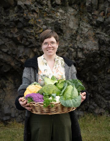 Elínborg Erla Ásgeirsdóttir and a sample of vegetables from Breiðargerði Farm