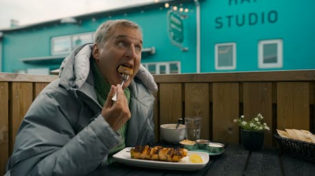Philip Rosenthal of the Netflix show "Somebody Feed Phil" enjoying wolffish on a skewer at the Sea Baron restaurant in Reykjavík, Iceland.
