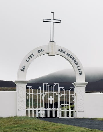 "Ég lifi og þér munuð lifa" on the gate to the old cemetery in the Westman Islands. The sign translates as: "I live, you will live also". The volcano in the back is called Eldfell.