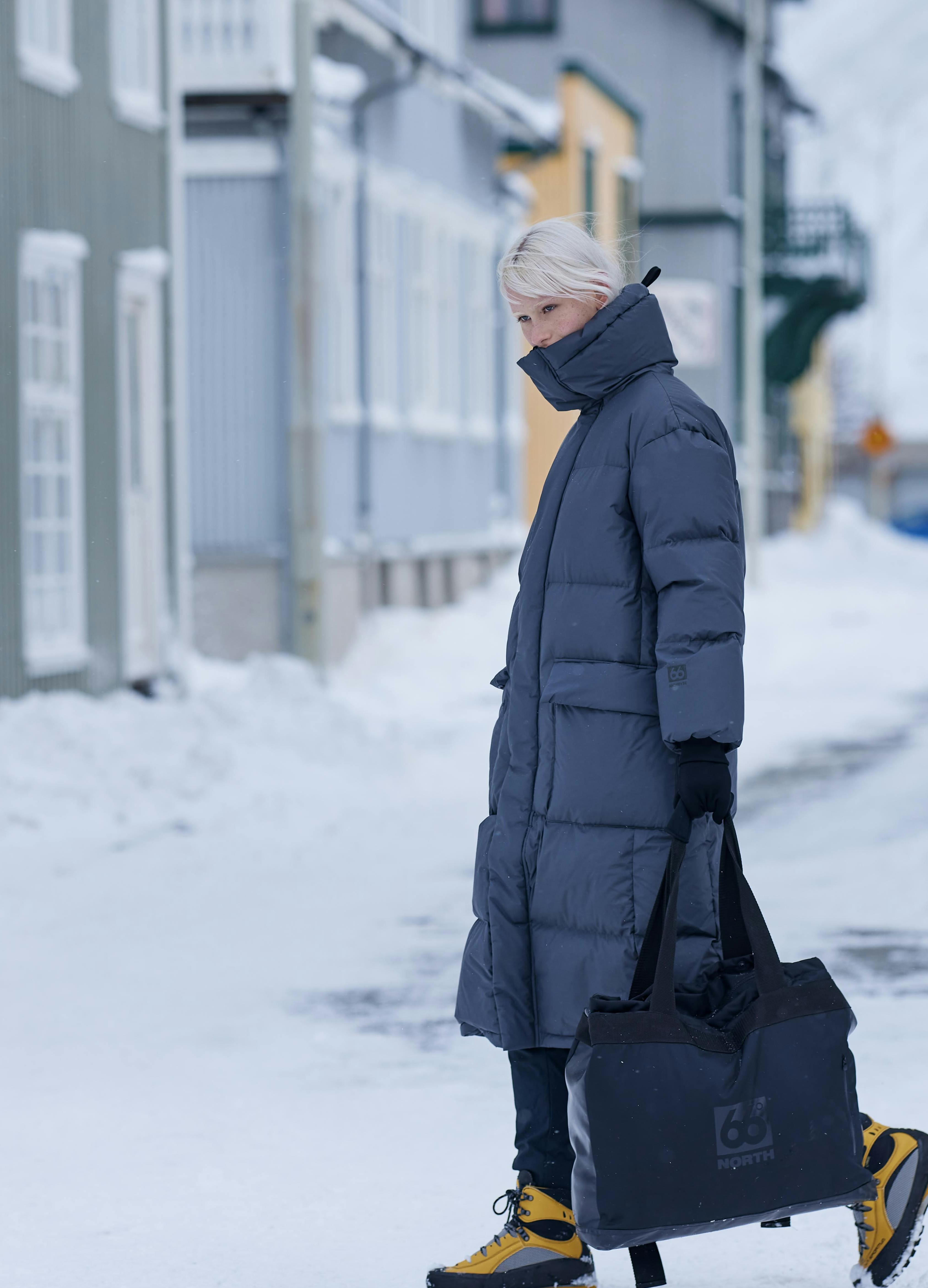 Girl walking in snowy condition in 66 degrees north clothing