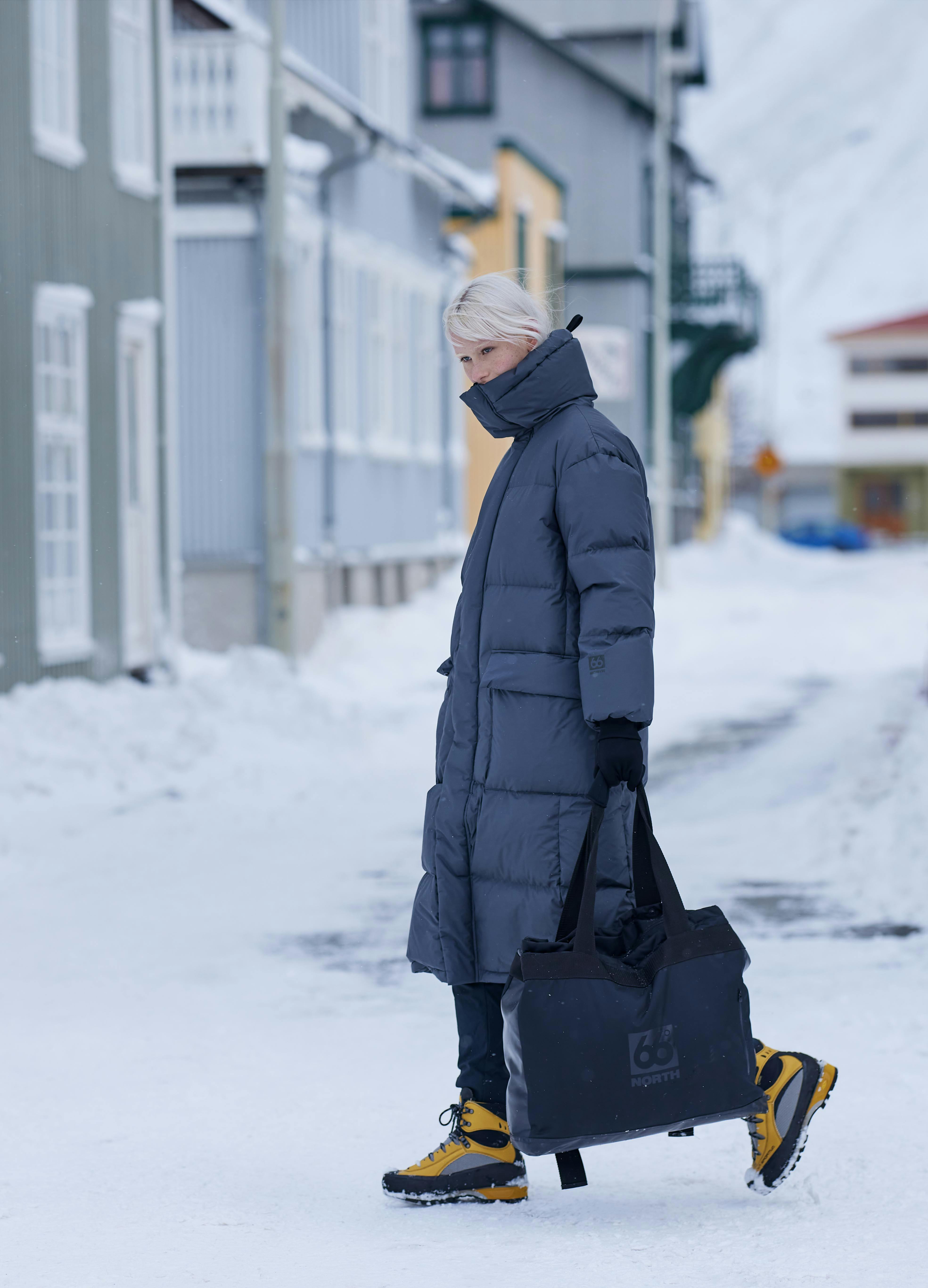 Girl walking in snowy condition in 66 degrees north clothing