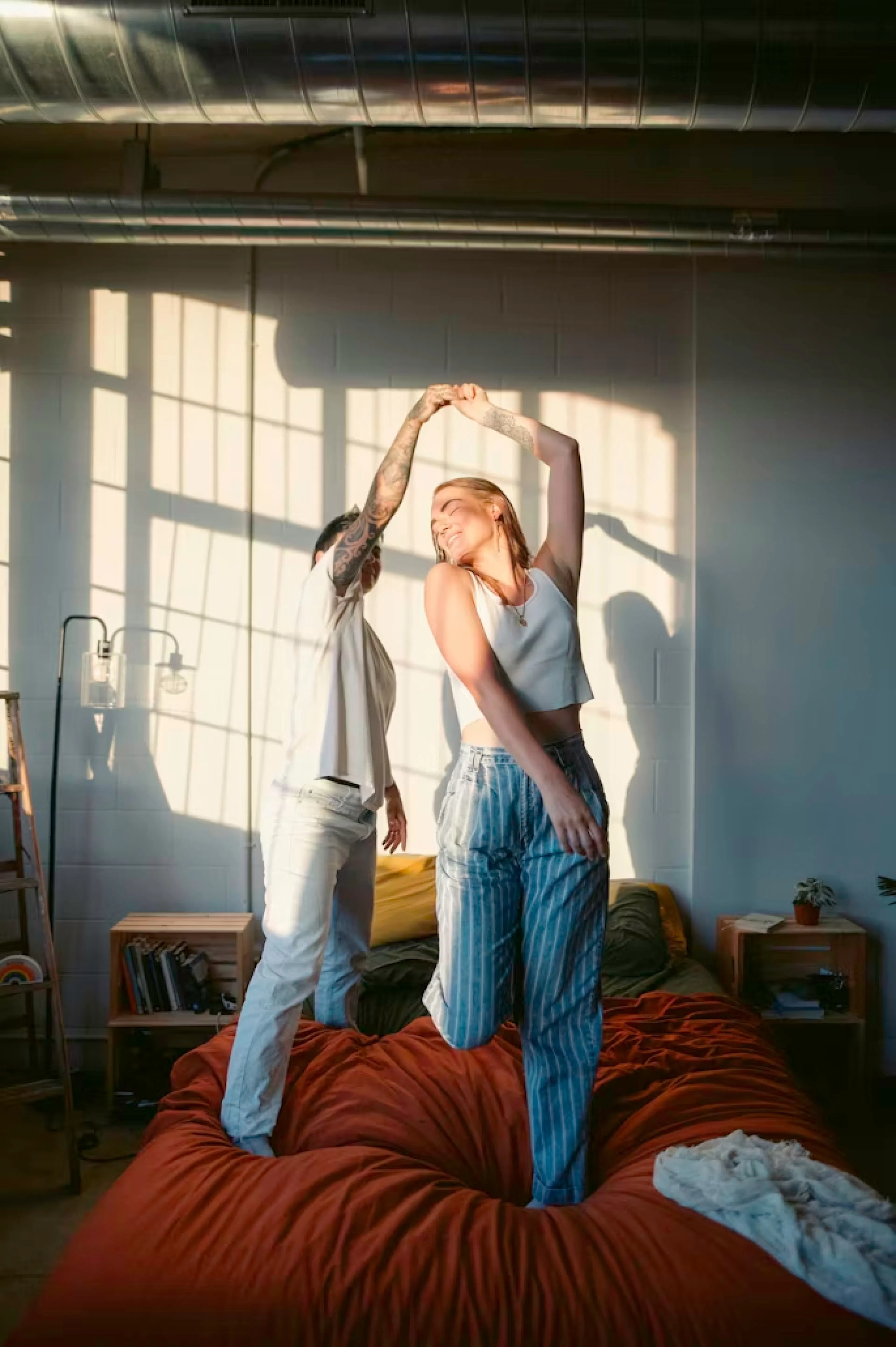 Casal alegre em cima da cama dançando