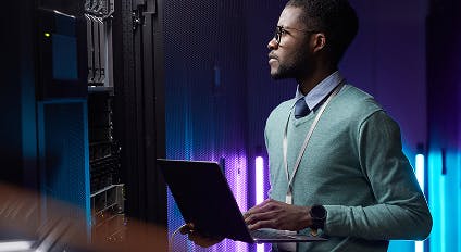 a worker looking at his laptop and desktop computer screen