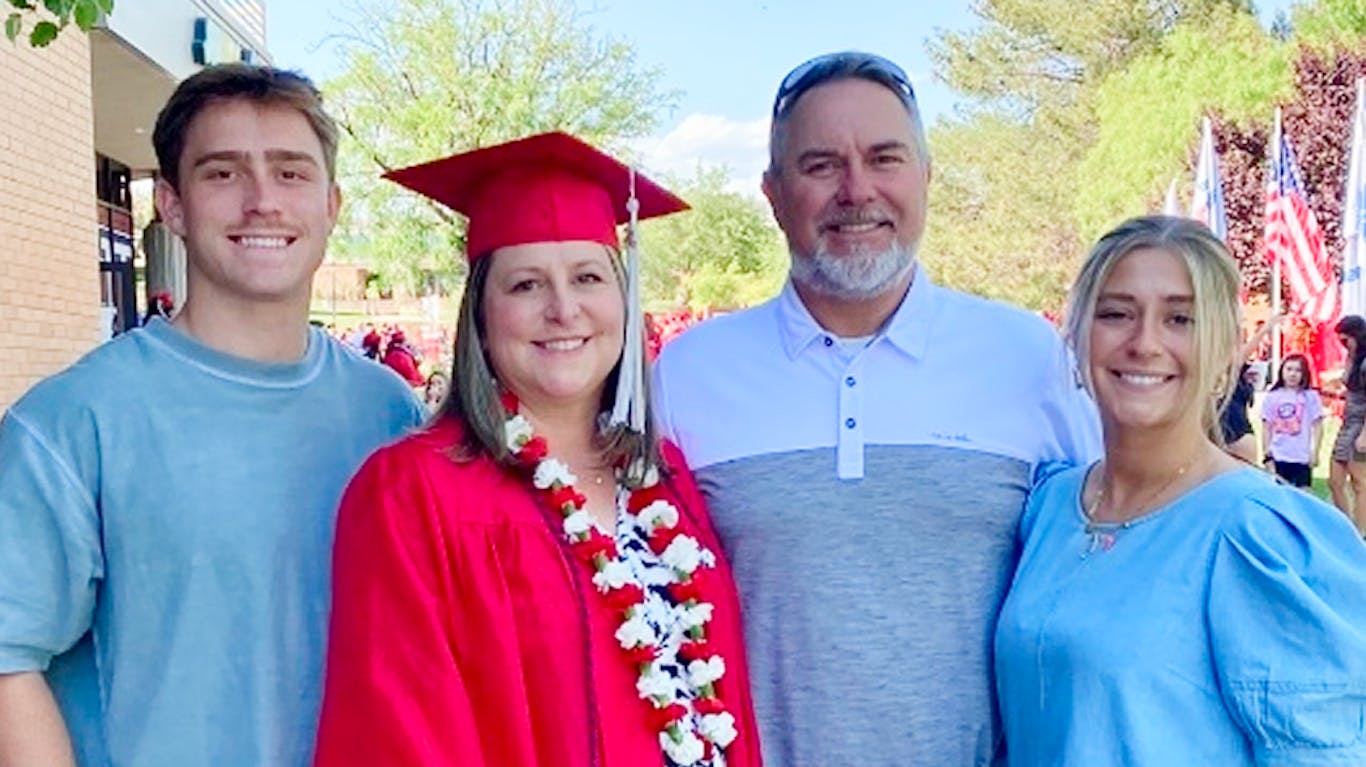 employee learner at graduation with their family