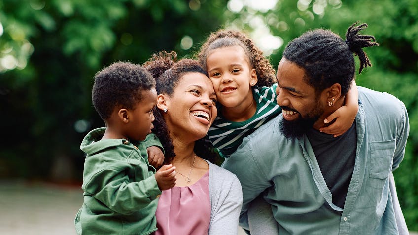 a happy family of four smiling and spending time together
