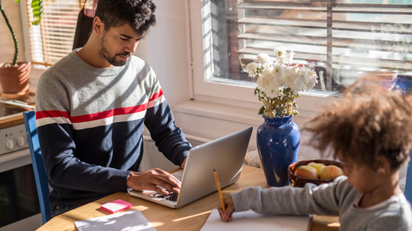 a person on their computer with a child nearby