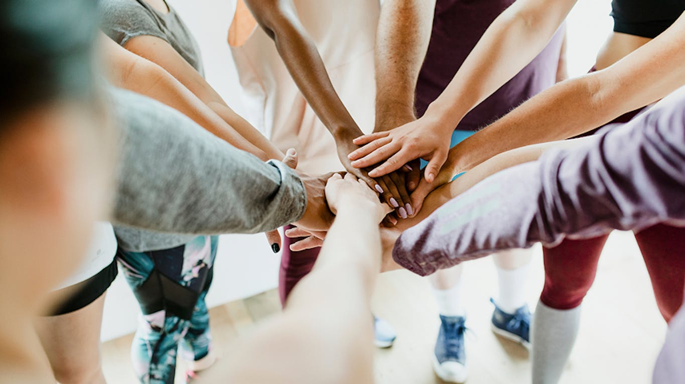 a team with all of their hands in a circle
