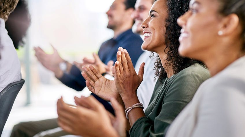 people at work smiling and clapping