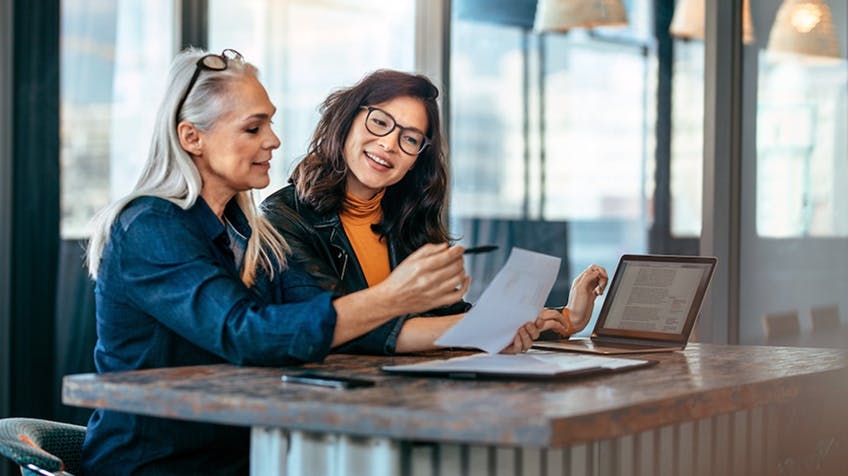 two people looking at a piece of paper together