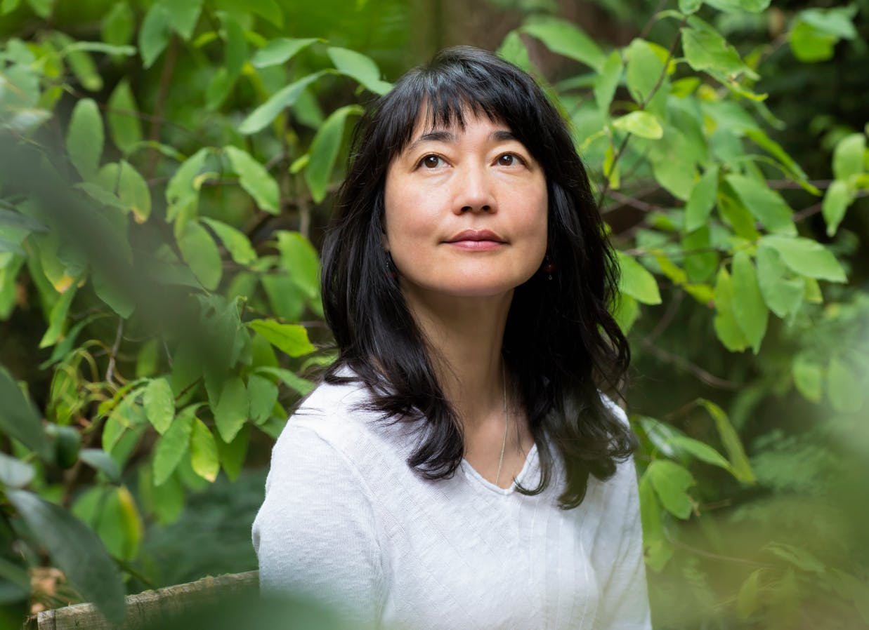 woman looking aspirationally into the distance surrounded by greenery