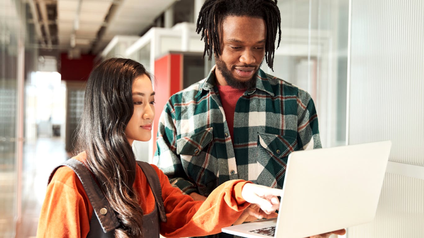 two people looking at a laptop together