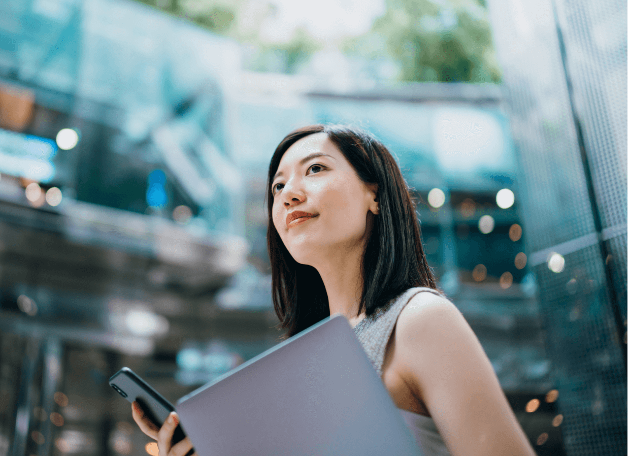 woman holding her phone and computer