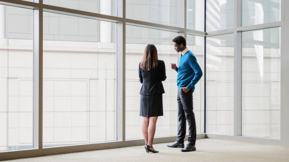 two financial services employees talking at work