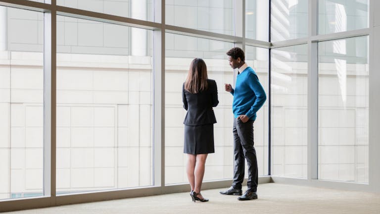two financial services employees talking at work