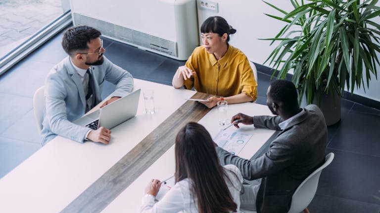 people at work sitting around a table