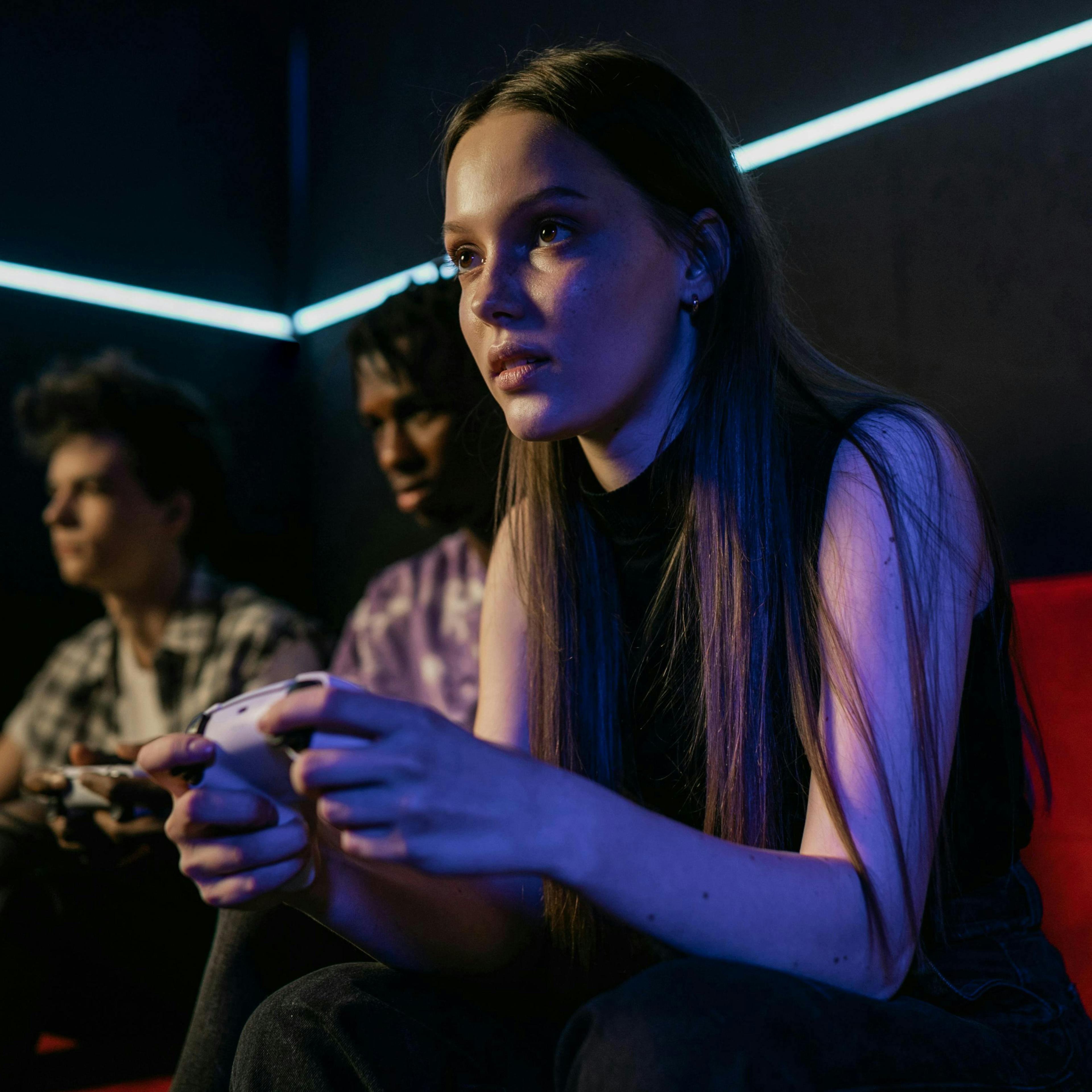 Young person holding a controller playing video games