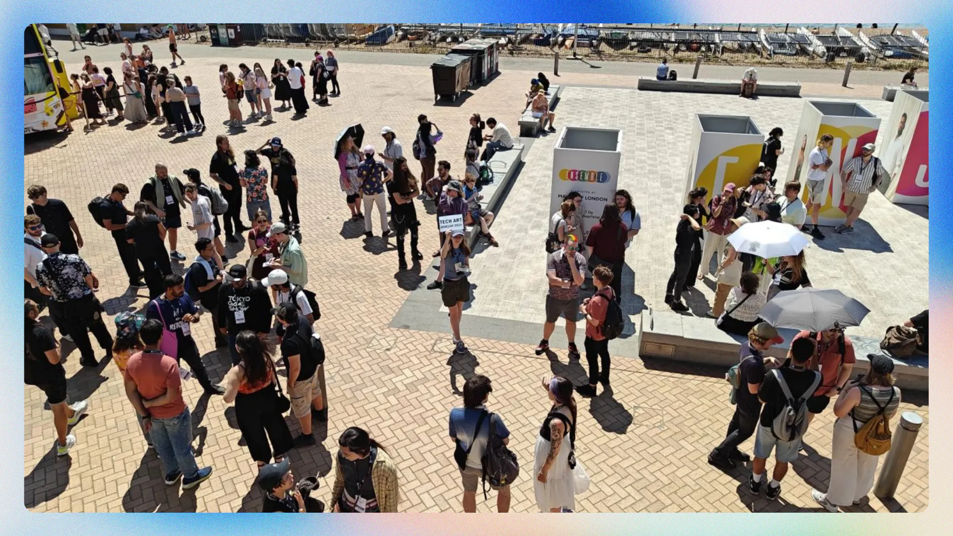 Image of a group of people on the beach. A woman stands in the middle holding a 'tech art meetup' sign.