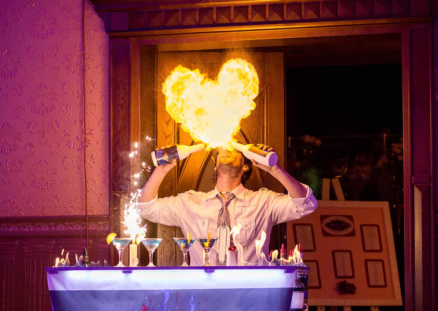 Barmen, düğün salonu içerisinde içki kokteyli hazırlarken alevler püskürterek gösteri sergiliyor.