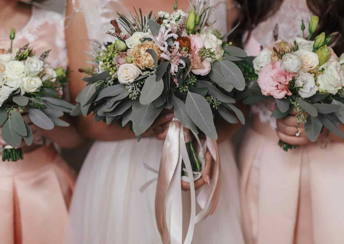 Yakın plan çekimde; gelin ve nedimeler, ellerinde gelin çiçeği tutuyor.