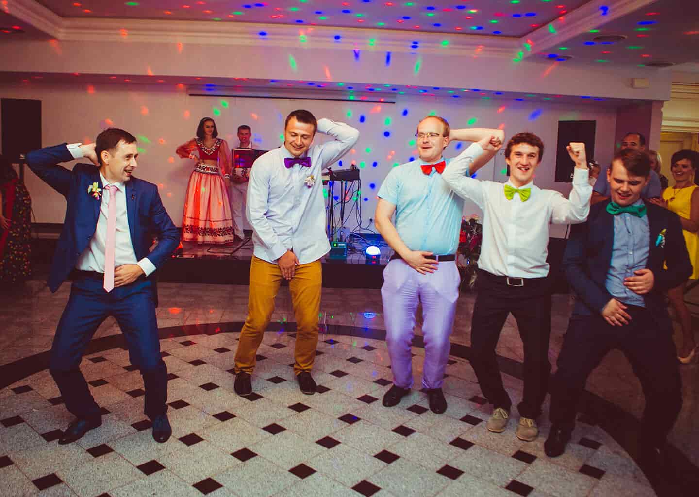 Düğün salonunda olan damat ve sağdıçlar boyunlarından ve bellerinden tutarak dans ediyorlar.