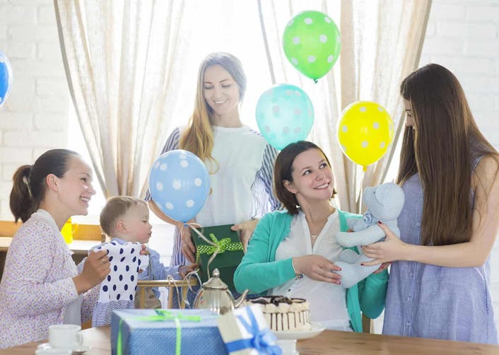 Baby shower partisi veren kadının evinde, davetliler kadına hediyeler veriyor. 