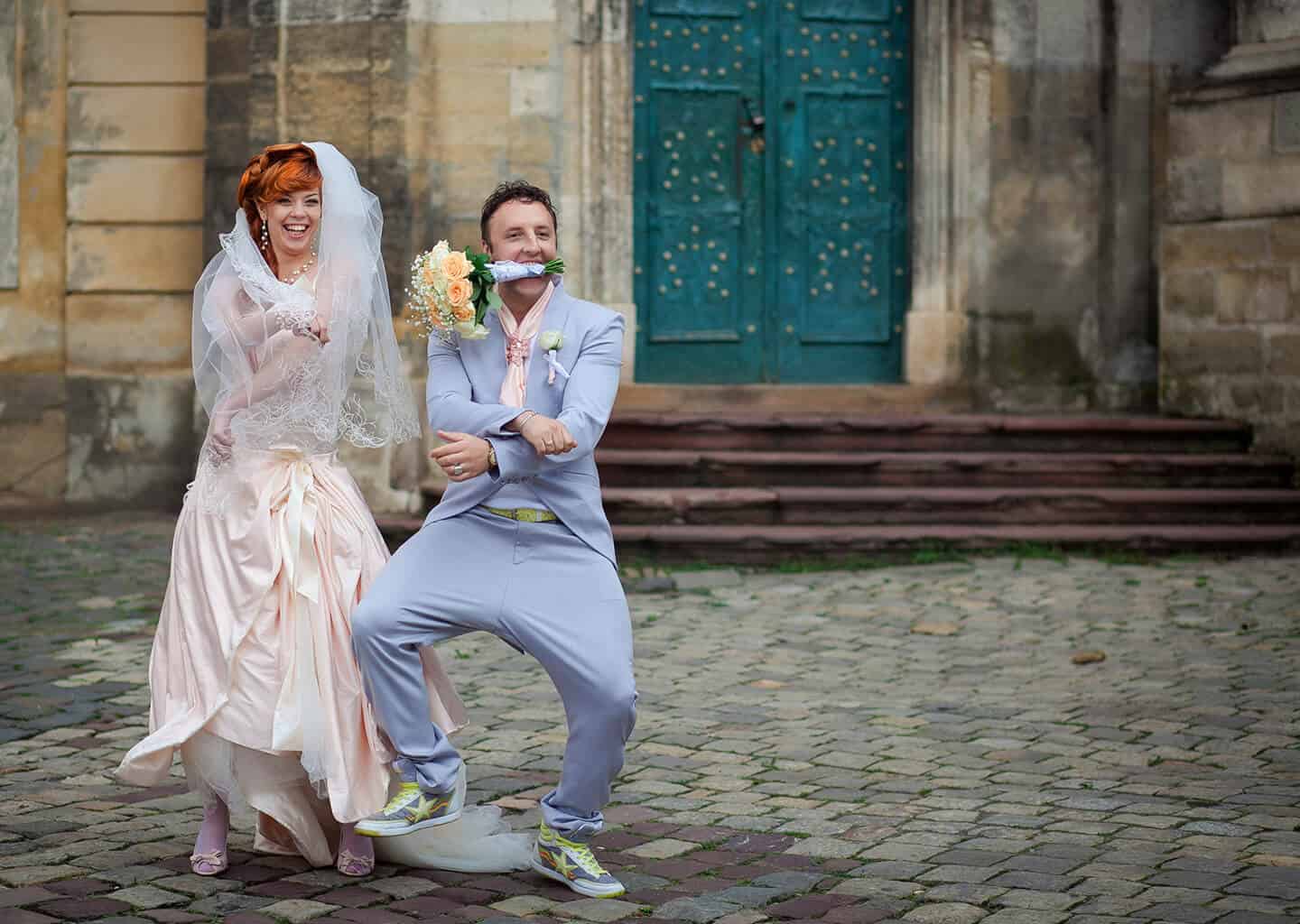 Sokakta duran gelin ve damat gülümseyerek dans ediyor. Damadın üzerinde lila bir damatlık ve gelinin üzerinde ise pudra tonlarında saten bir gelinlik bulunuyor.