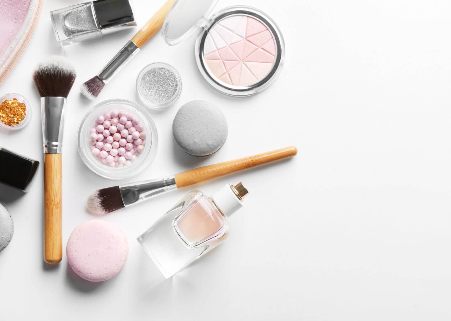 Açık renk arka plan üzerinde makyaj malzemeleri bulunuyor.