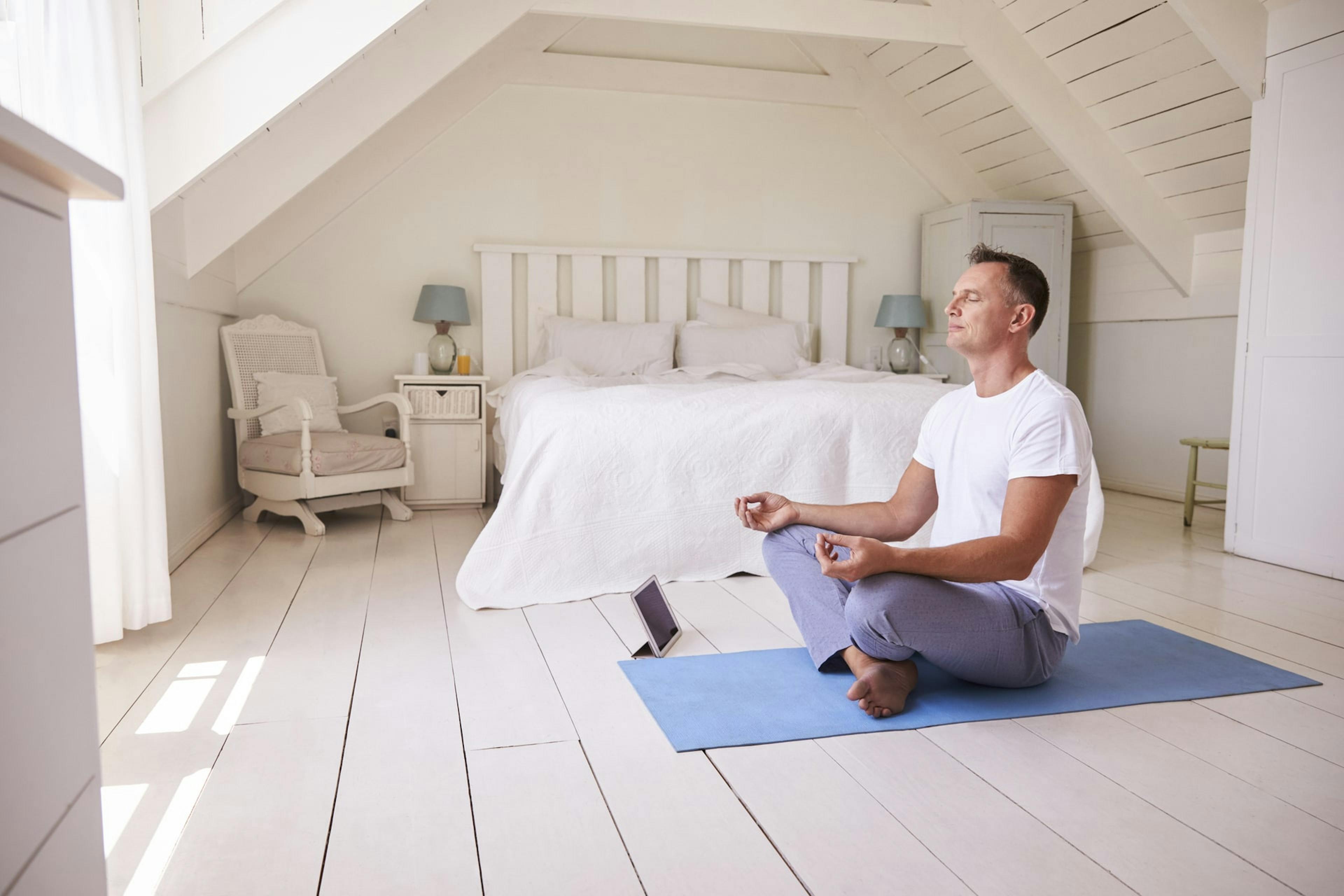Mann meditiert auf einer Yoga-Matte und denkt über eine Lebensveränderung nach