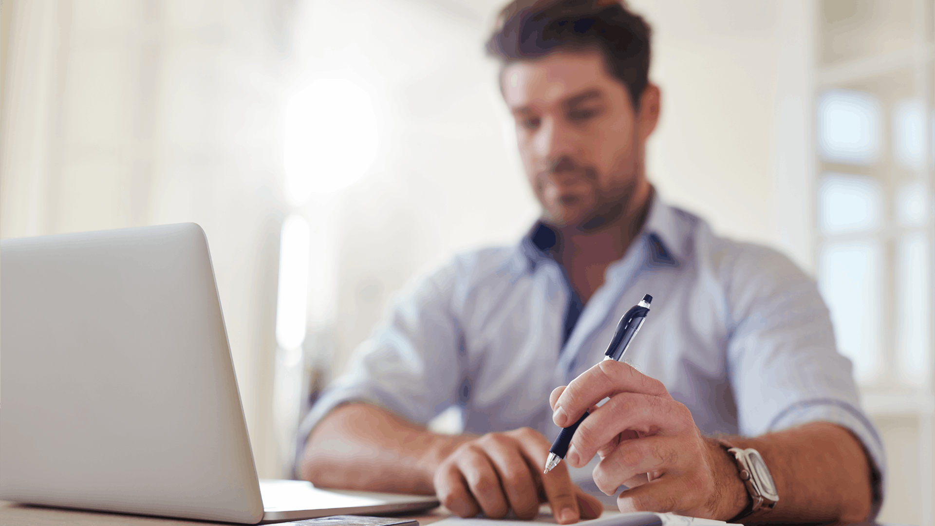 Geschäftsmann zu Hause im Büro mit Laptop und Notizen