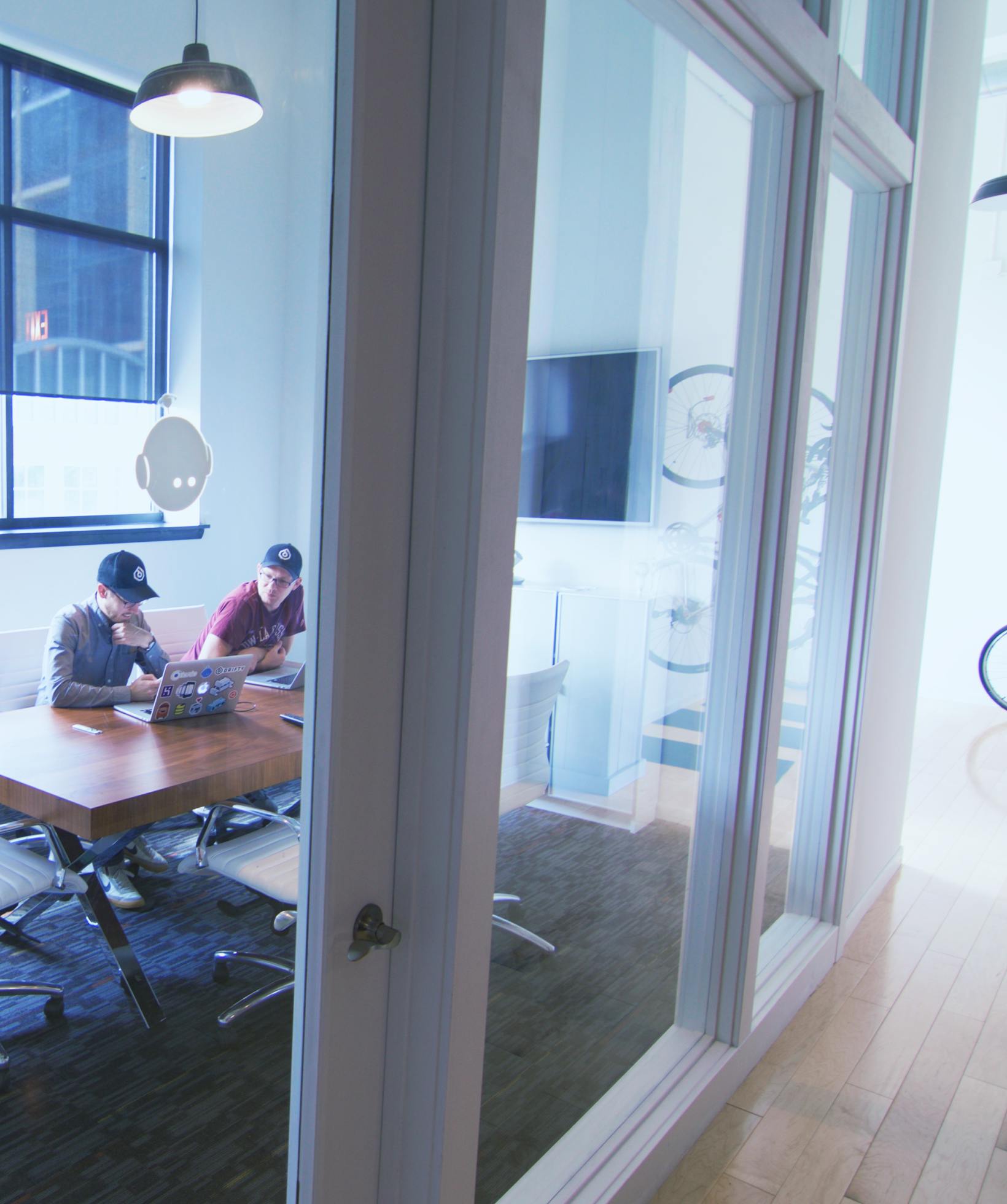 Ben Sperry and Adam Bradley in conference room on laptops