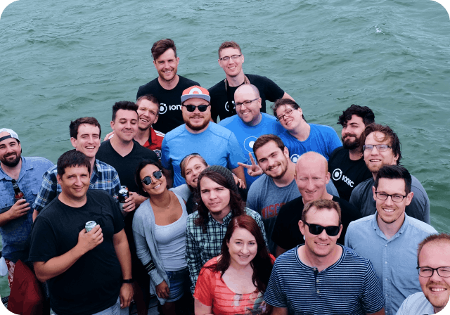 Ionic team gathered in triangle formation next to water