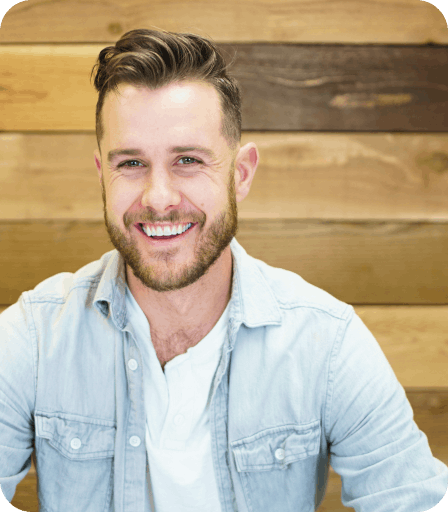 Ionic team memeber Brody Kidd smiling against a wooden backdrop
