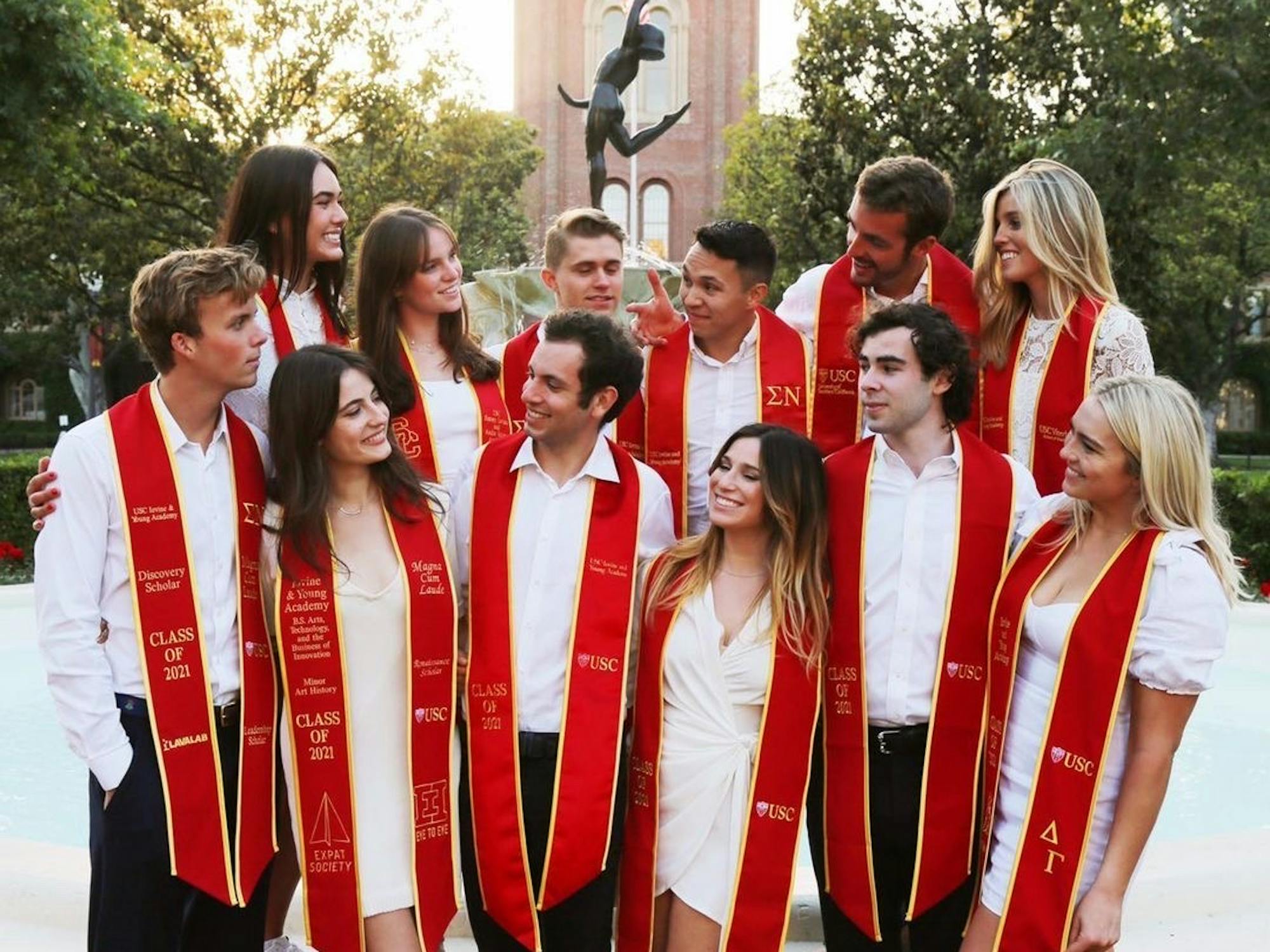 Group of graduating students wearing white and red sashes