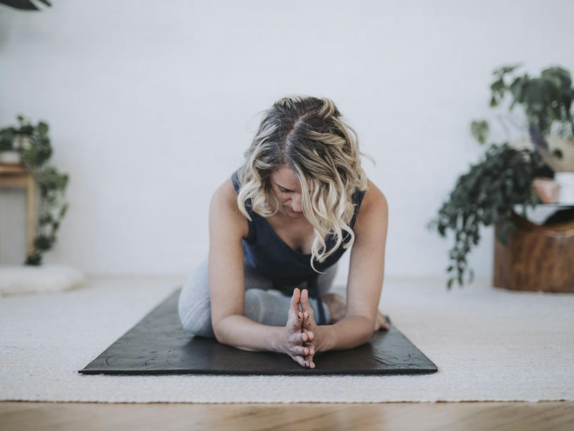 A woman poses on a yoga mat, focusing intently