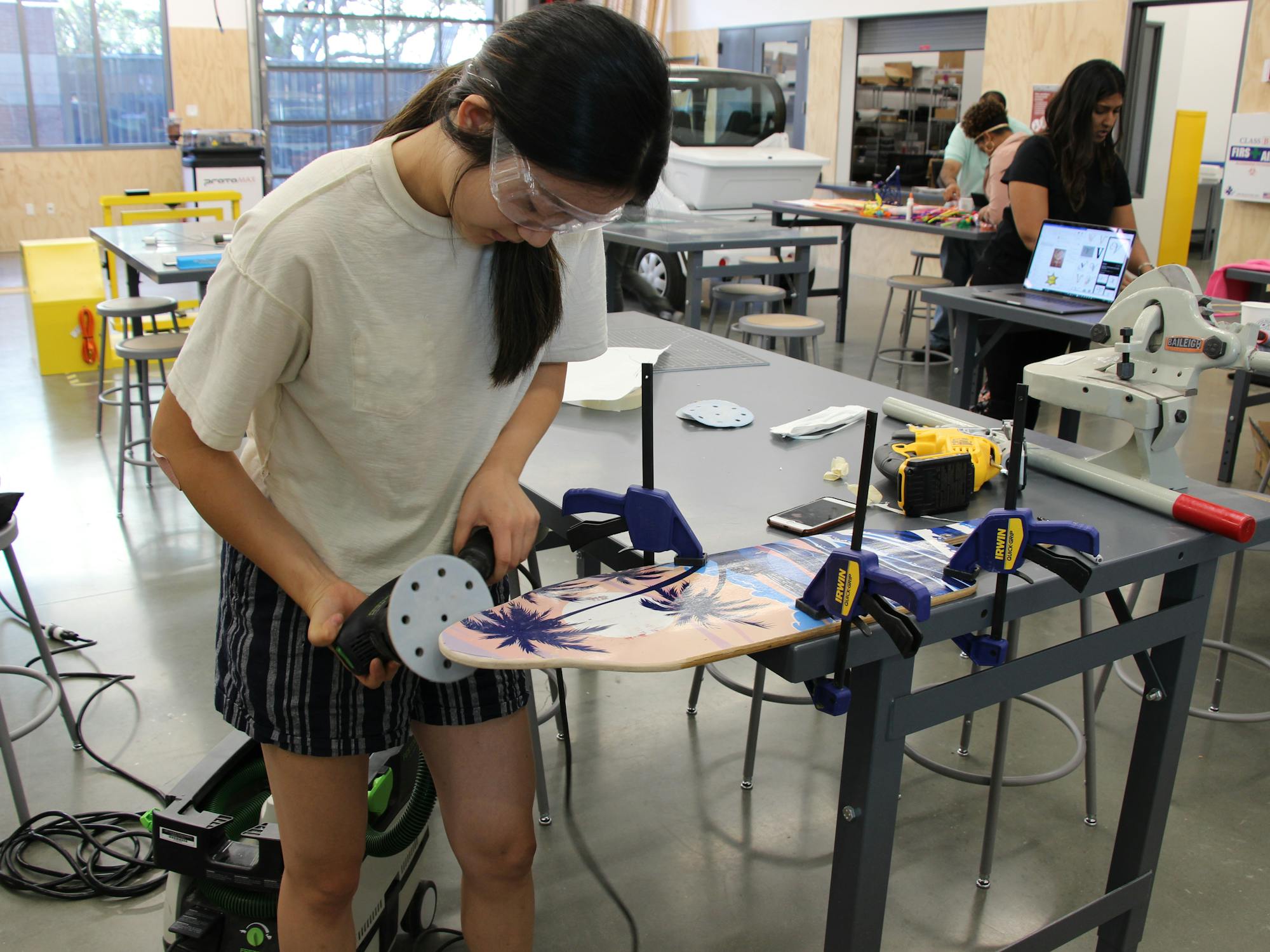 Female student making a skateboard in workshop
