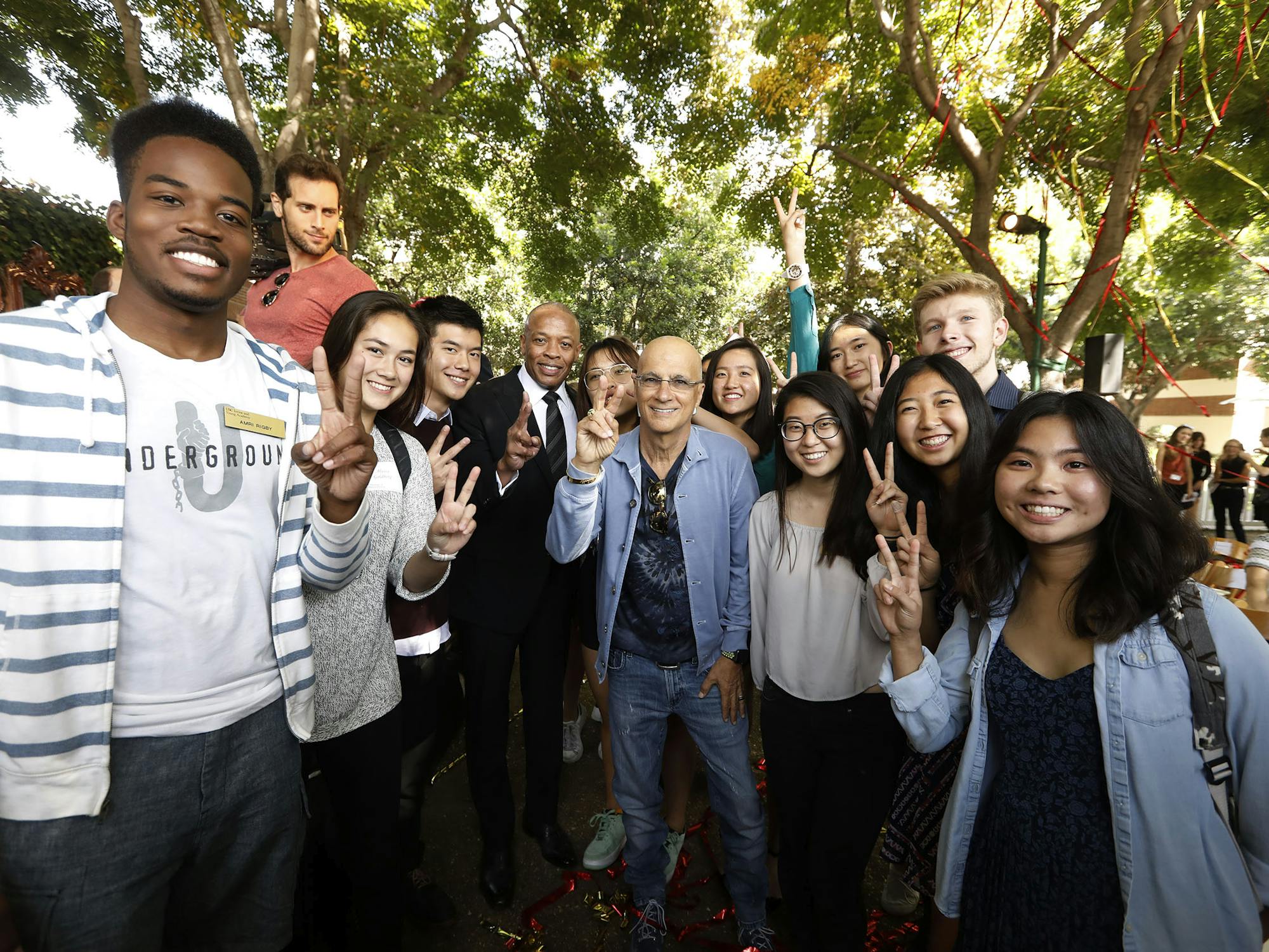 Group of students posing for photos with hand gesture for peace sign