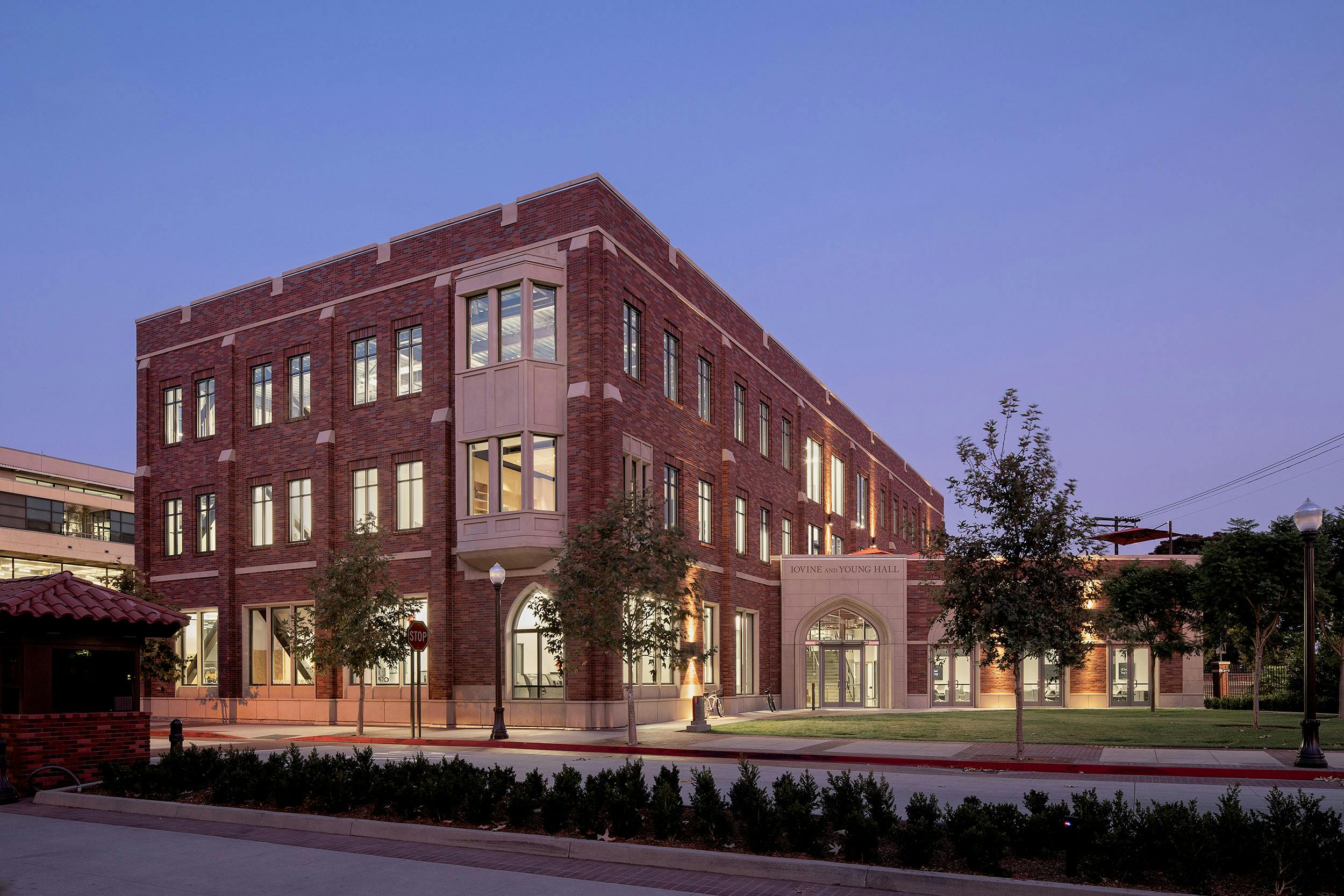 A red brick building with lights on in the evening